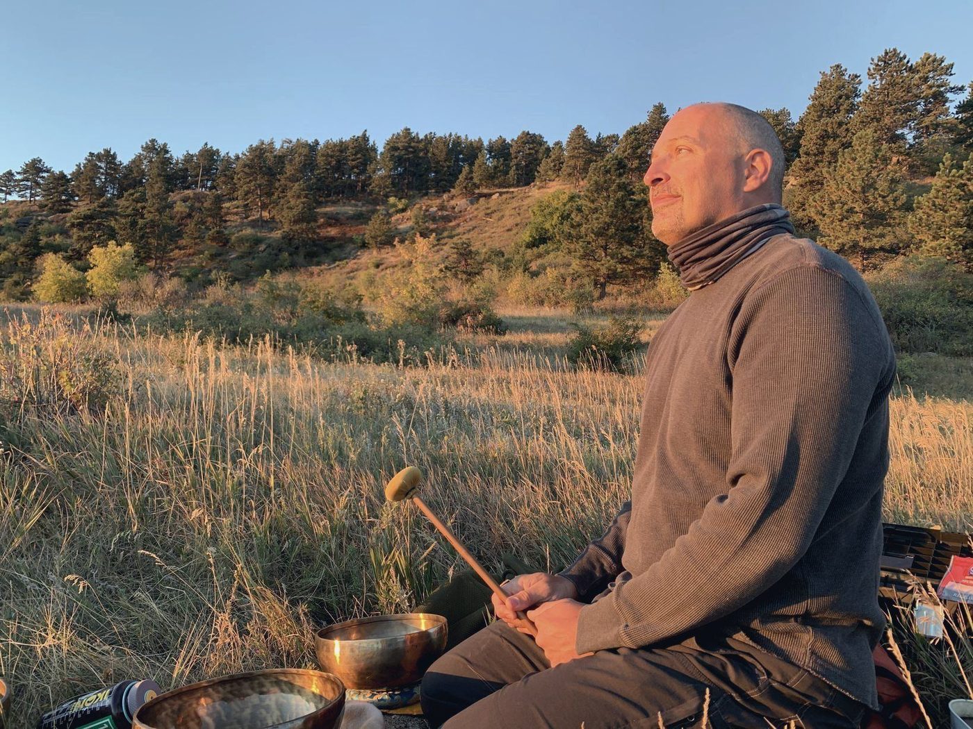 Martyn Church with singing bowls in a meadow at golden hour