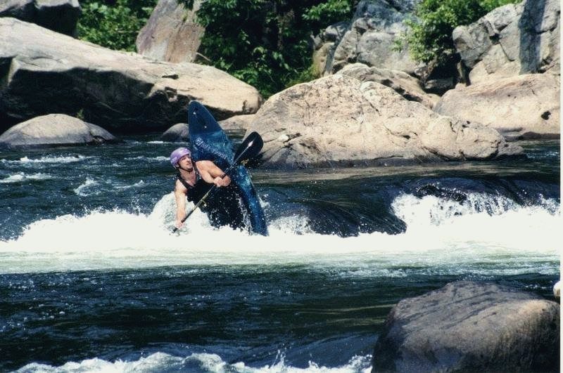 Martyn Church paddling a blue kayak through a rapid