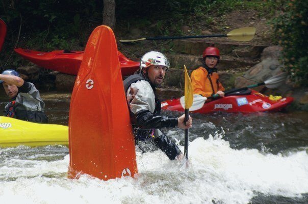 Martyn Church running whitewater in an orange kayak